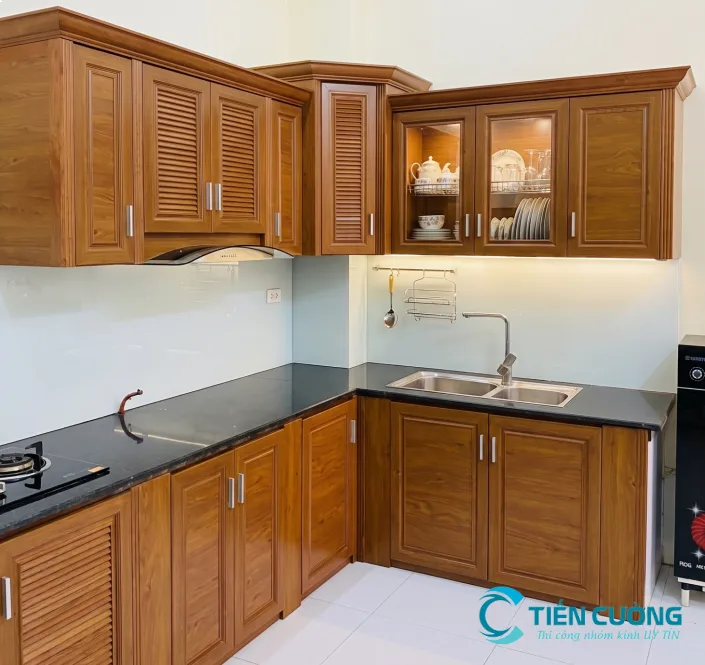 Mẫu tủ bếp chữ L nhôm kính đẹp: phối màu, kiểu cánh và bố cục - hình ảnh thực tế Tủ bếp nhôm kính vân gỗ chữ L đẹp